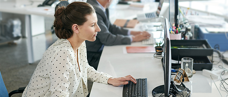 Zakenvrouw in kantoor aan het werk achter haar computer